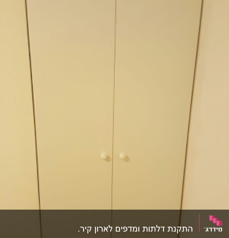 ארון עץ לבן עם שתי דלתות וידיות עגולות